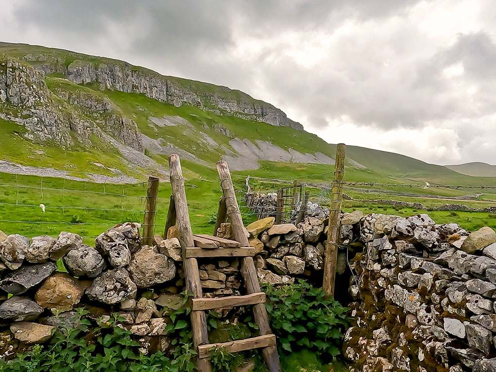 Stile over the wall with Attermire Scar ahead