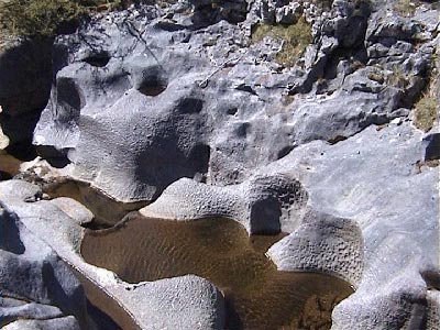 The stragely eroded rocks under the footbridge