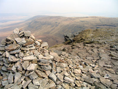 Path heads back down after the cairn, below the small cliff