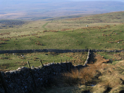 Wide grassy path leads away from the wall